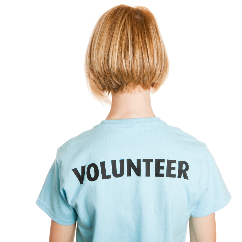 the back of a young person with short blonde hair. they are wearing a light blue shirt with Volunteer across their shoulders.
