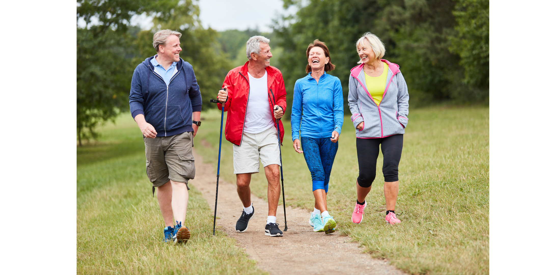 Four older people walking on a mountain trail. They are all wearing workout wear and sneakers.