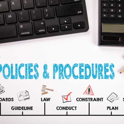 a keyboard and calculator on a white desk. There is writing on the desk. Policies and procedures. regulations. standards. guideline. law. conduct. constraint. plan. solution